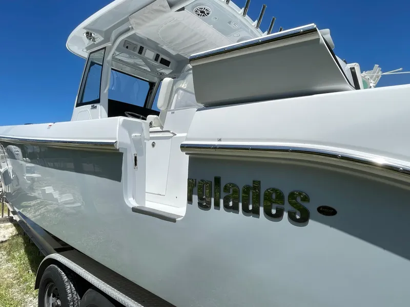 Slide: The Image of 2025 Everglades 315 Center Console boat, sleek design, white exterior, under clear blue sky. - 7