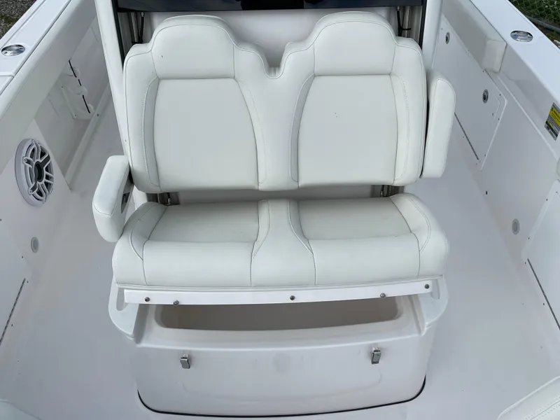 Slide: The Image of 2023 Everglades 235CC boat with white cushioned seating and storage compartment. - 13