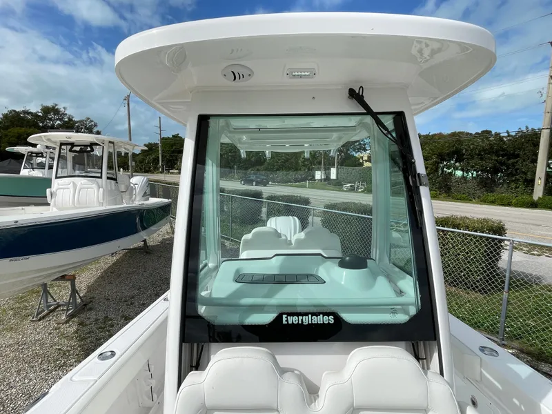 Slide: The Image of 2023 Everglades 235CC boat with sleek design, white seating, and clear windshield. - 16