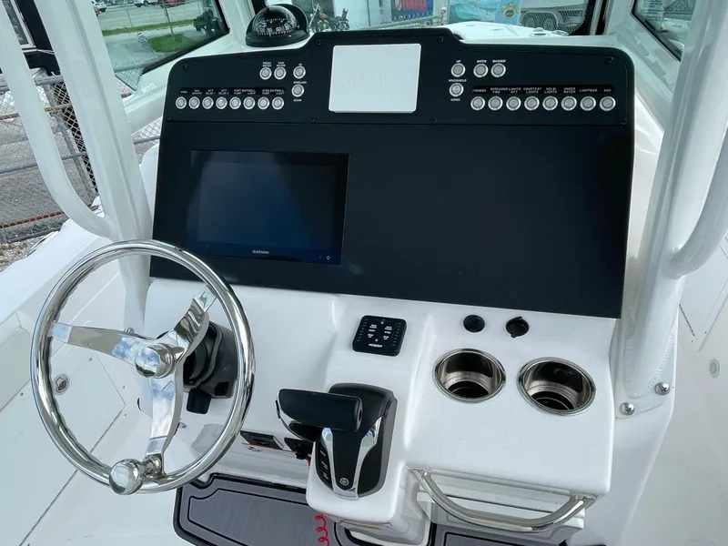 Slide: The Image of 2023 Everglades 235CC boat dashboard with steering wheel, touchscreen, and control panel. - 19