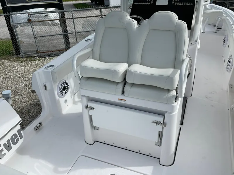Slide: The Image of 2023 Everglades 235CC boat with dual white cushioned seats and storage compartment. - 23