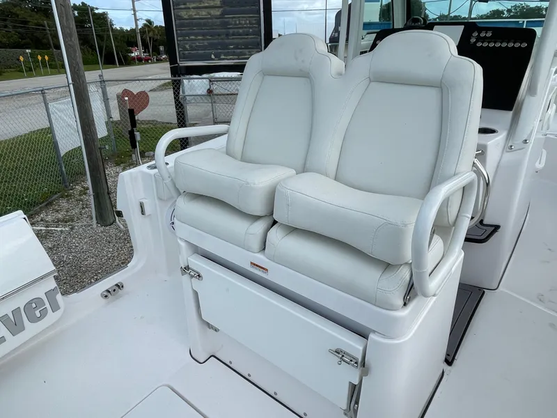 Slide: The Image of 2023 Everglades 235CC boat with dual white cushioned seats and storage compartment. - 24