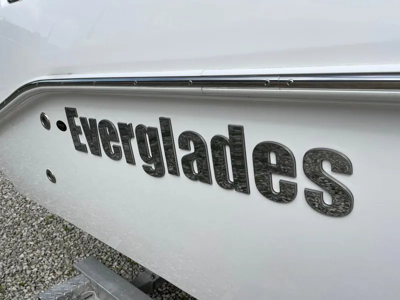 Slide: The Image of 2023 Everglades 235CC boat logo on white hull, close-up view. - 4