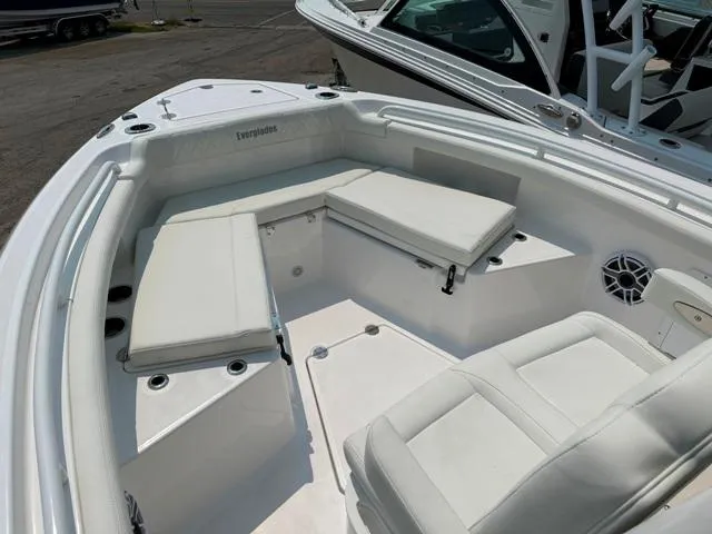 Slide: The Image of 2023 Everglades 235CC boat interior with white cushioned seating and speaker. - 8
