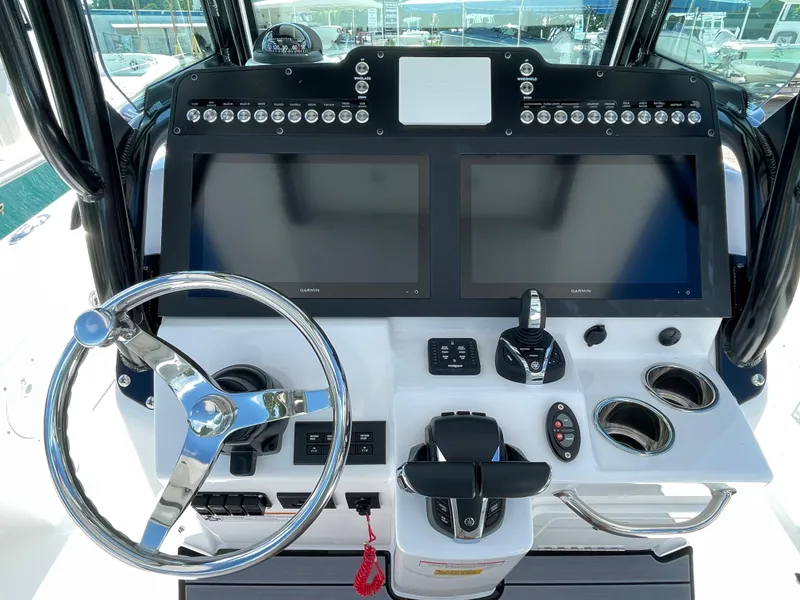 Slide: The Image of 2023 Everglades 273CC boat dashboard with dual screens and steering wheel. - 11
