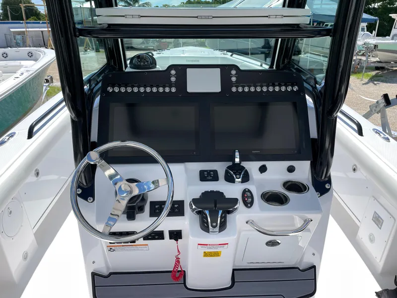 Slide: The Image of 2023 Everglades 273CC boat dashboard with steering wheel and control panel. - 12