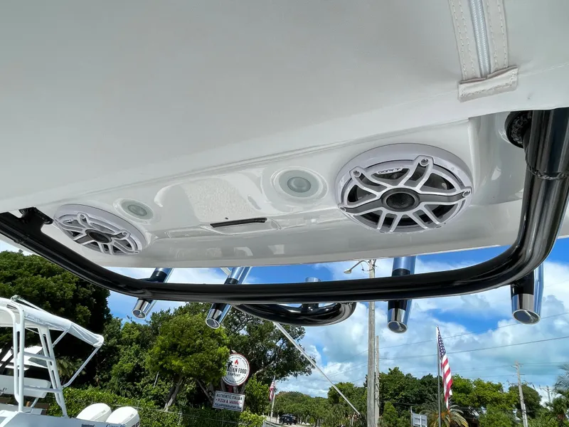 Slide: The Image of 2023 Everglades 273CC boat speakers and rod holders under a clear blue sky. - 15