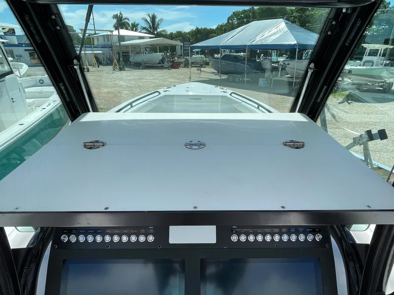 Slide: The Image of 2023 Everglades 273CC boat dashboard with dual screens and outdoor view. - 19
