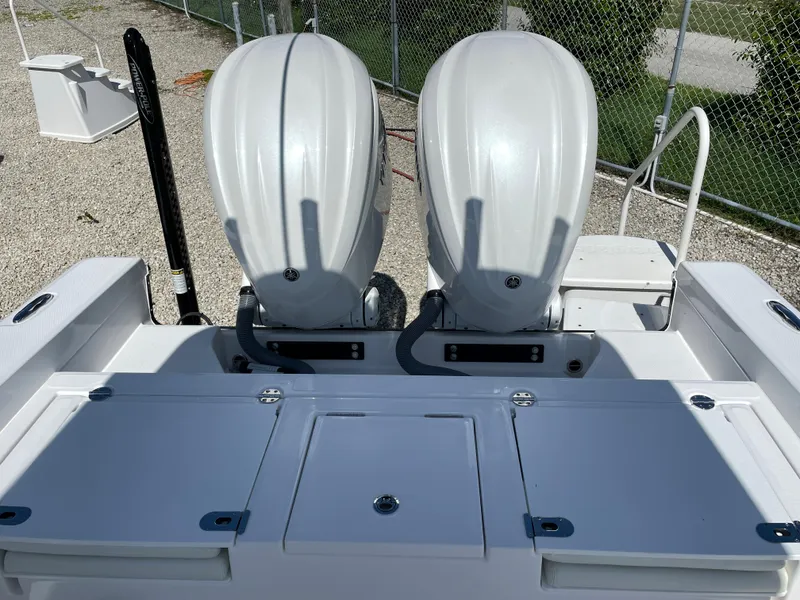 Slide: The Image of 2023 Everglades 273CC boat with dual outboard engines, parked on gravel. - 24