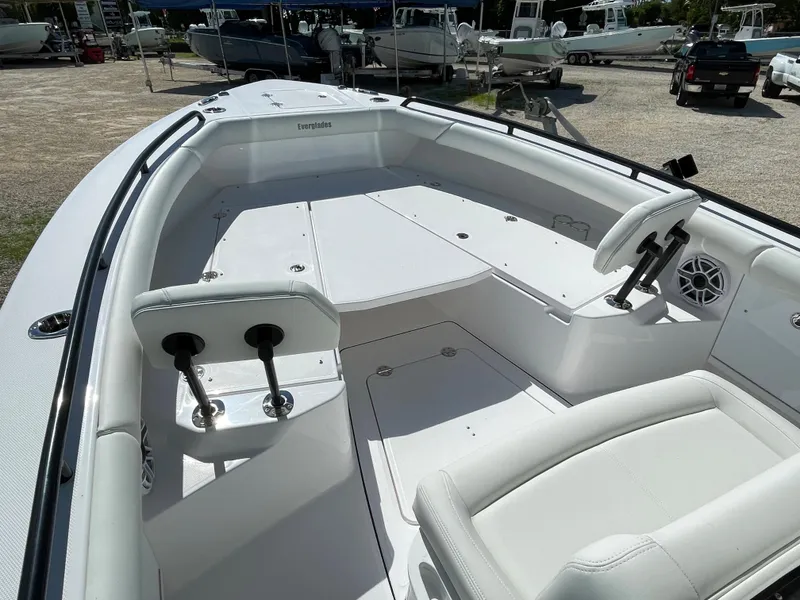 Slide: The Image of 2023 Everglades 273CC boat interior with seating and steering wheel, in a marina setting. - 4