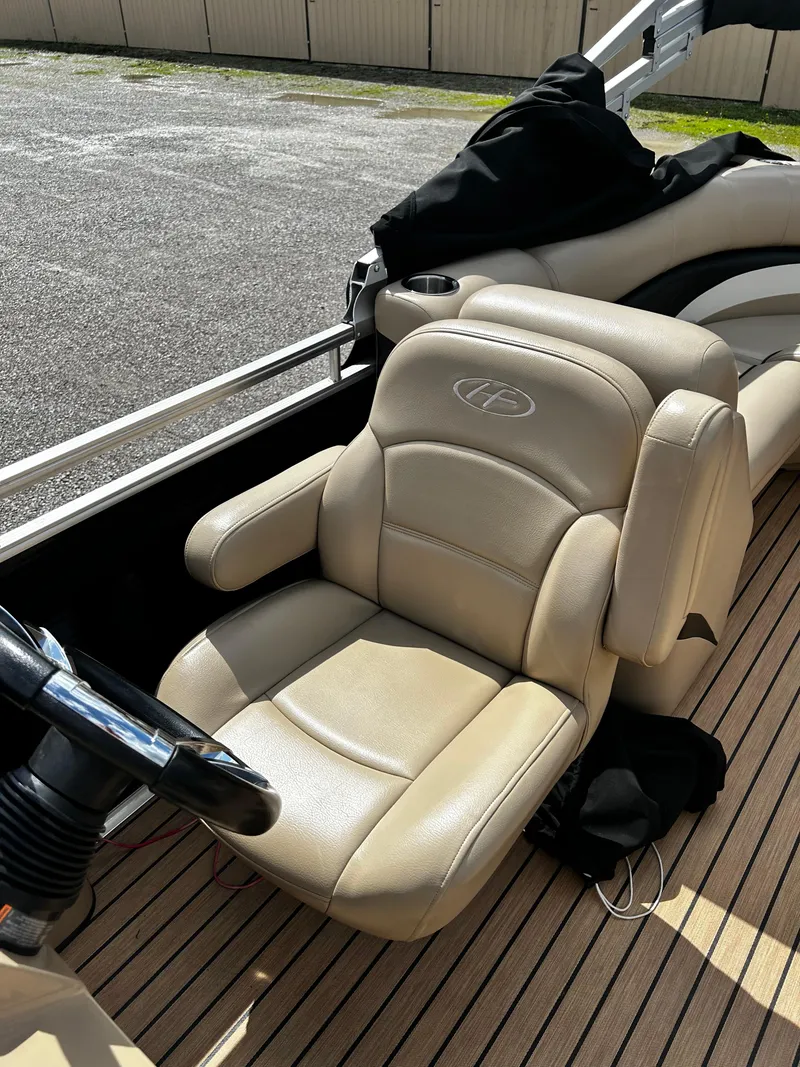 Slide: The Image of 2014 Harris FloteBote 200 Cruiser CS boat interior with beige captain's chair and steering wheel. - 10
