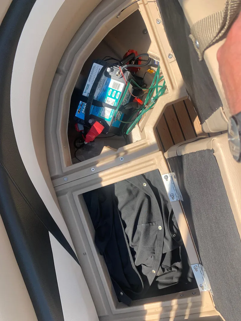 Slide: The Image of 2014 Harris FloteBote 200 Cruiser CS storage compartment with battery and clothing. - 17