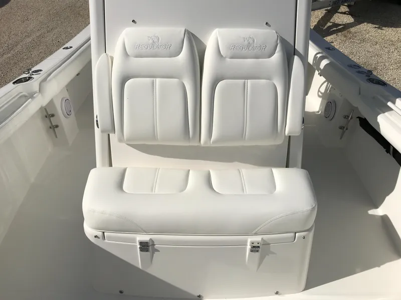 Slide: The Image of 2023 Regulator 23 boat with white cushioned seating and storage compartment. - 13