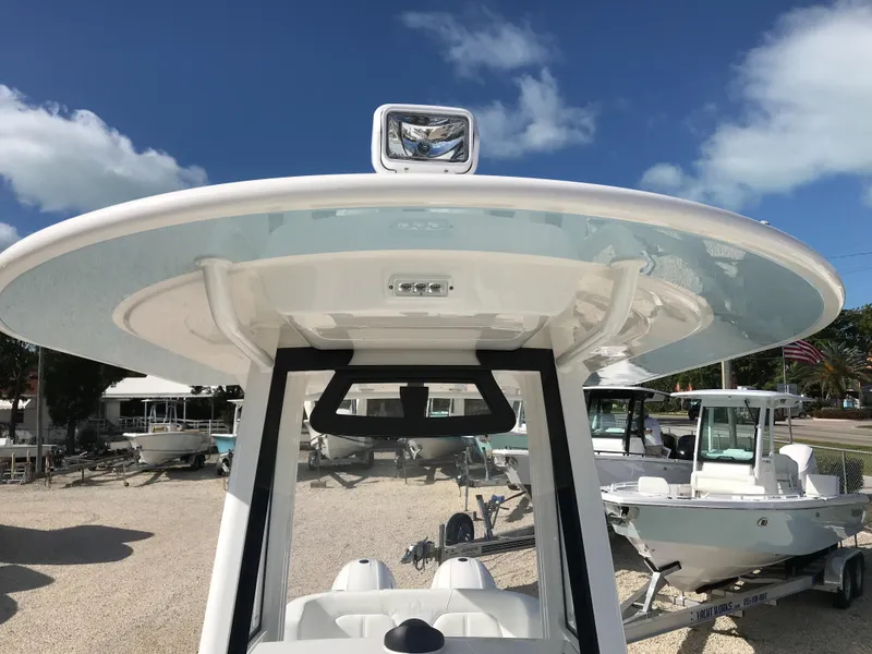 Slide: The Image of 2023 Regulator 23 boat with T-top and spotlight under a clear blue sky. - 15