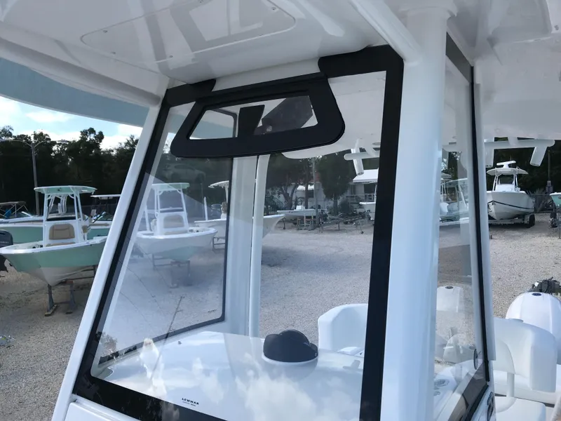 Slide: The Image of 2023 Regulator 23 boat with sleek windshield design in a marina setting. - 18