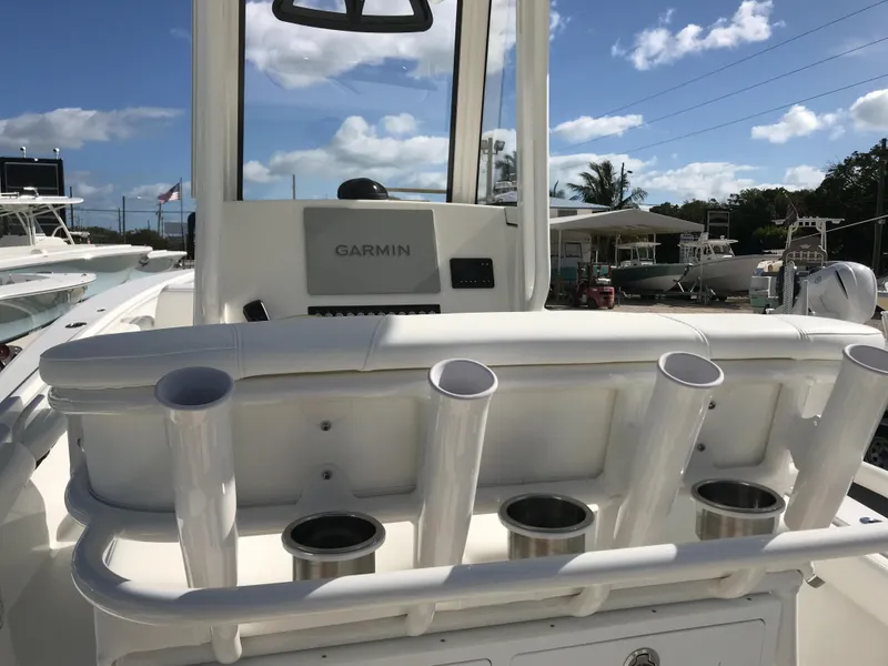 Slide: The Image of 2023 Regulator 23 boat with Garmin system and rod holders, under a clear blue sky. - 23
