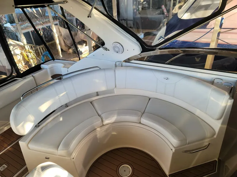 Slide: The Image of 2006 Regal Commodore 3560 IB boat with white curved seating and wooden deck. - 16