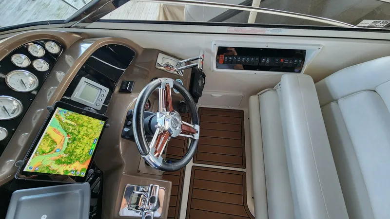 Slide: The Image of 2006 Regal Commodore 3560 IB helm with modern navigation equipment and wood accents. - 23