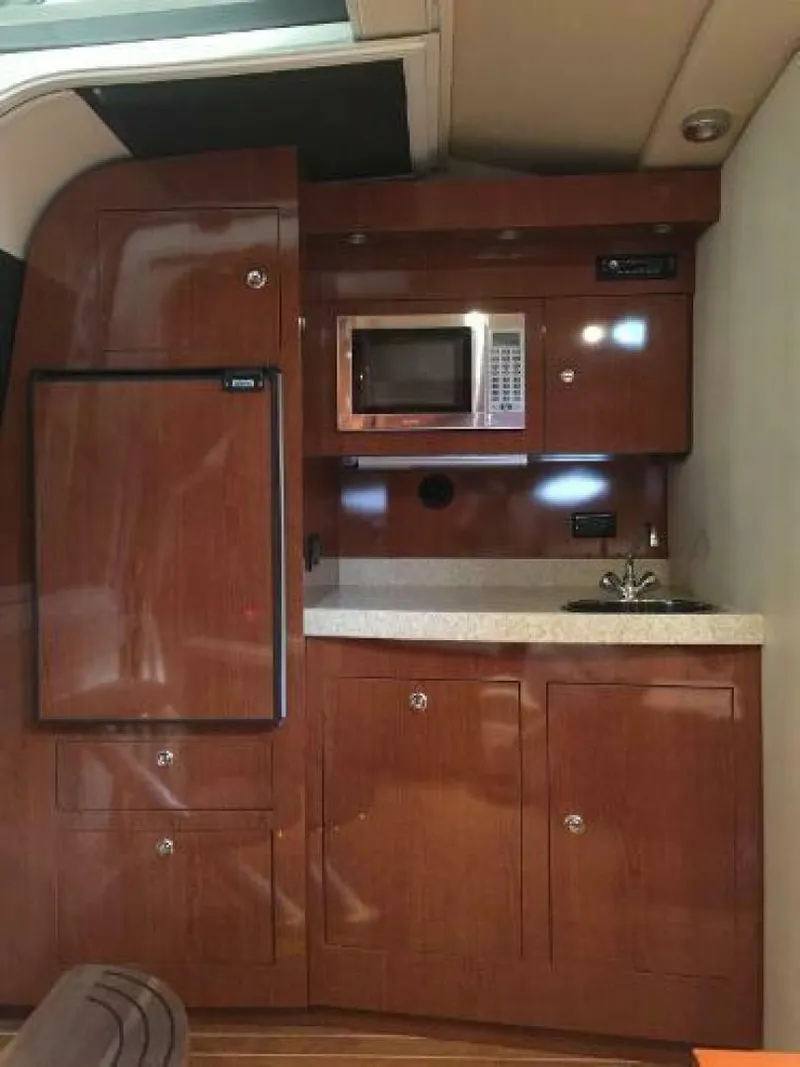 Slide: The Image of 2006 Regal Commodore 3560 IB yacht kitchen with wood cabinets, microwave, and compact fridge. - 7