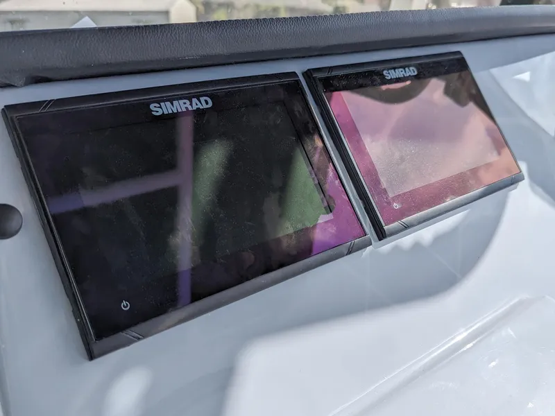 Slide: The Image of Simrad displays on 2025 Bayliner Trophy T22CC boat dashboard. - 2