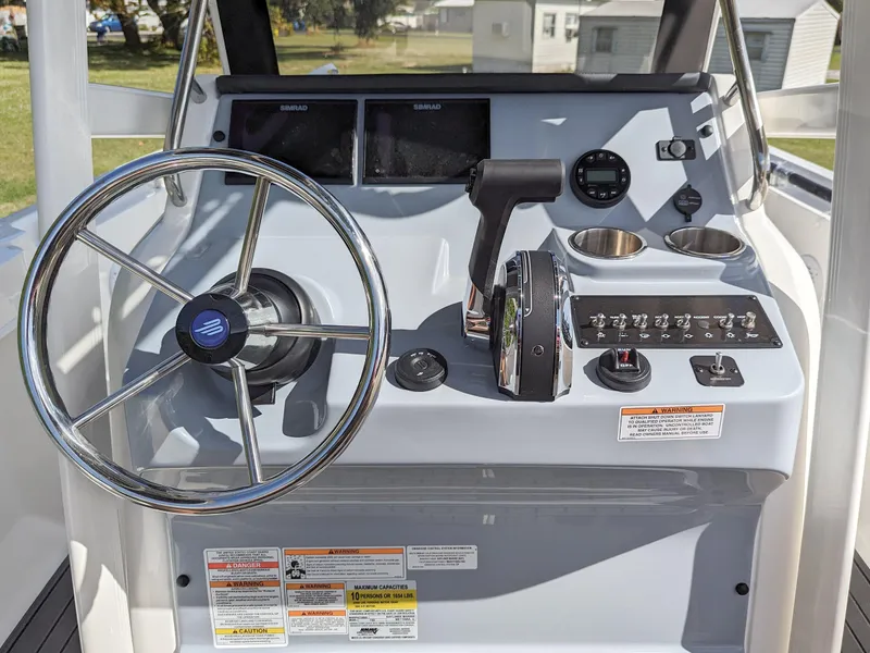 Slide: The Image of 2025 Bayliner Trophy T22CC helm with steering wheel, controls, and dual displays. - 3