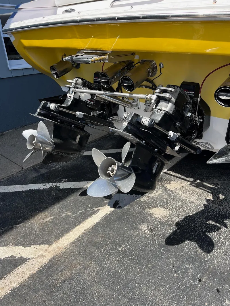 Slide: The Image of 1998 Donzi 33ZX boat with dual propellers and yellow hull, parked on pavement. - 10