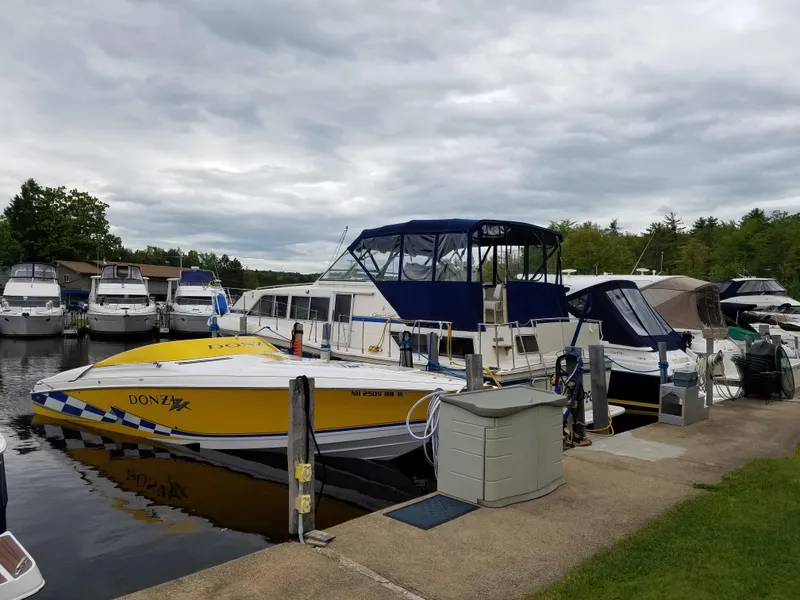 Slide: The Image of Yellow 1998 Donzi 33ZX speedboat docked at a marina with other boats. - 3