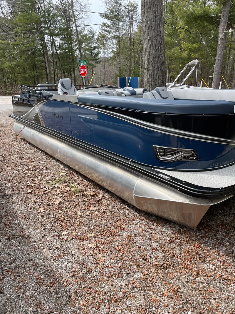 Slide: The Image of 2025 Avalon 25 LSZ Elite pontoon boat in a wooded area, showcasing sleek design and modern features. - 6