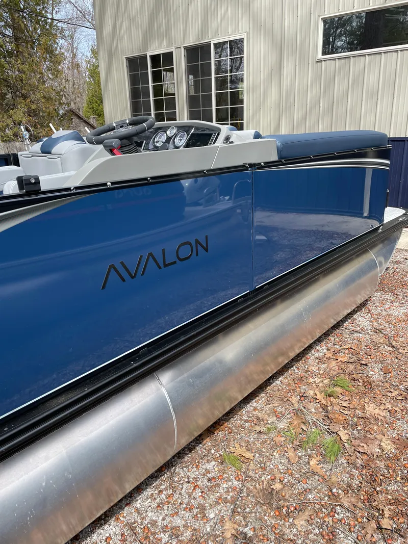 Slide: The Image of 2025 Avalon 25 LSZ ELITE pontoon boat, blue exterior, parked outdoors. - 8