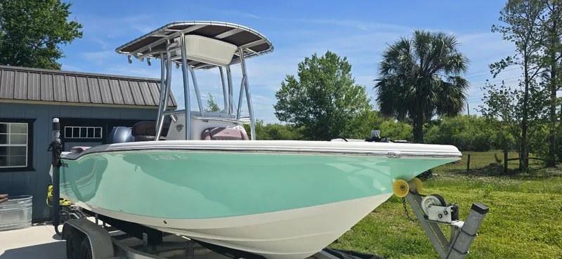 The Image of 2017 Tidewater 210 LXF boat on trailer, parked outdoors near a building. - 1