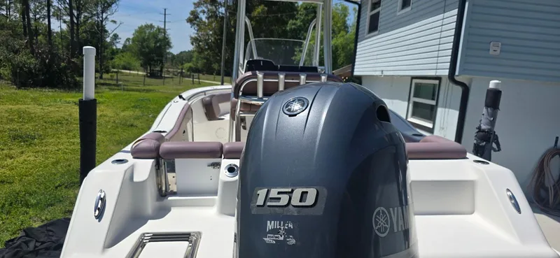 Slide: The Image of 2017 Tidewater 210 LXF boat with Yamaha 150 engine, parked near a house. - 10