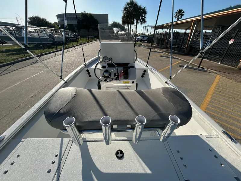 Slide: The Image of 2025 Avid 19 FSX boat interior with steering wheel and rod holders, docked under sunny skies. - 15