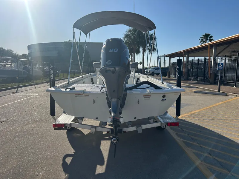Slide: The Image of 2025 Avid 19 FSX boat with outboard motor, parked on a trailer in a sunny lot. - 4
