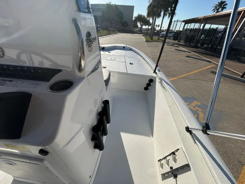 Slide: The Image of 2025 Avid 19 FSX boat interior, showcasing console and seating area in a sunny marina. - 7