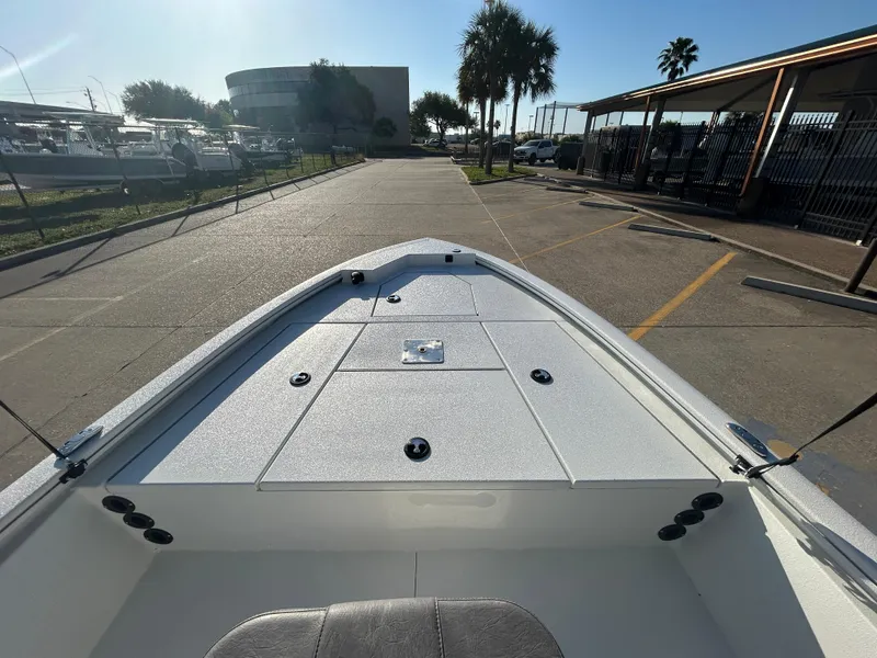 Slide: The Image of 2025 Avid 19 FSX boat deck, parked in marina under clear blue sky. - 8