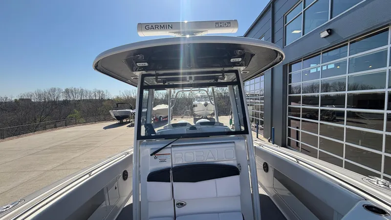 Slide: The Image of 2021 Robalo R302 Center Console boat with Garmin radar, docked near a modern building. - 16