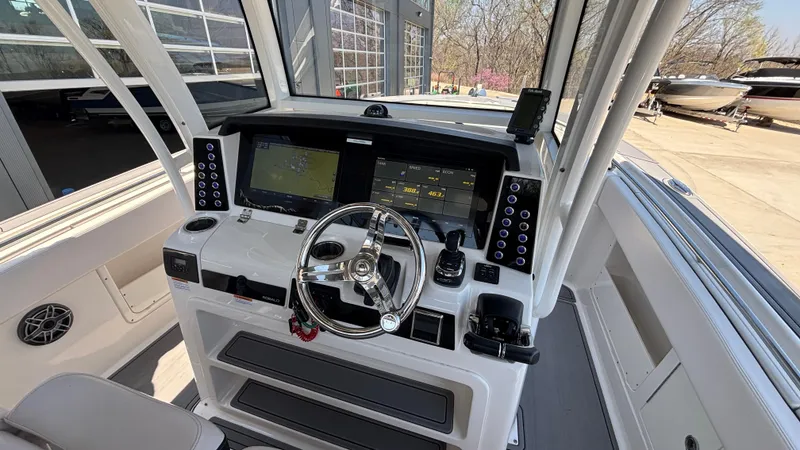 Slide: The Image of 2021 Robalo R302 Center Console boat cockpit with modern navigation system and steering wheel. - 34