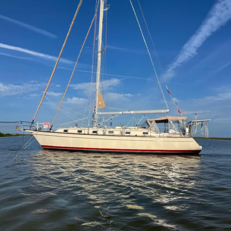 Slide: The Image of 2006 Island Packet 440 sailboat on calm water under a clear blue sky. - 0