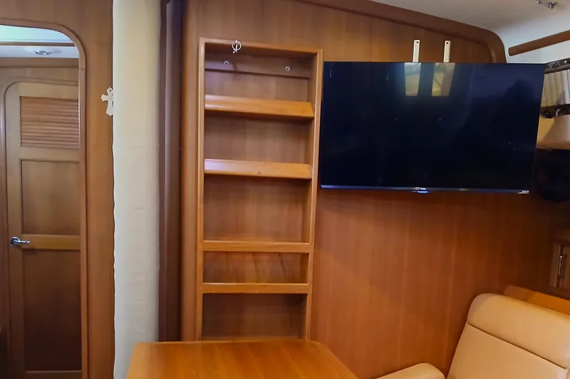 Slide: The Image of Interior of 2006 Island Packet 440 yacht with wooden shelves and mounted TV. - 11