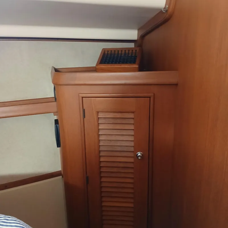 Slide: The Image of Wooden interior of 2006 Island Packet 440 yacht, featuring a cabinet with louvered door. - 17
