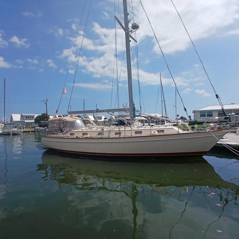 Slide: The Image of 2006 Island Packet 440 sailboat docked at marina under clear blue sky. - 2