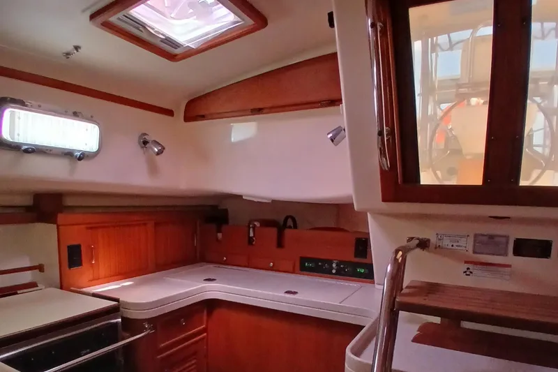 Slide: The Image of Interior of 2006 Island Packet 440 sailboat, featuring a well-equipped kitchen area. - 28