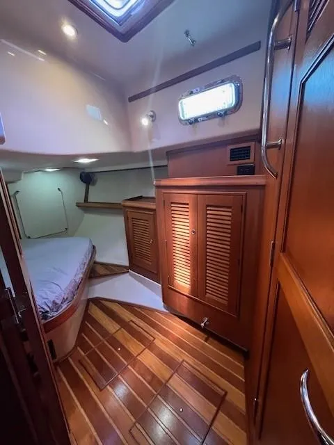 Slide: The Image of 2006 Island Packet 440 cabin interior with wooden flooring and cozy sleeping area. - 32