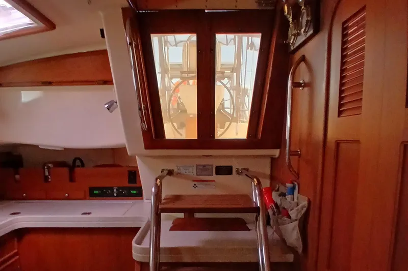 Slide: The Image of Interior of 2006 Island Packet 440 sailboat with wooden cabinetry and ladder. - 47
