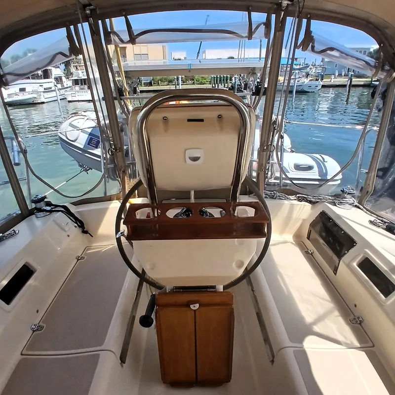 Slide: The Image of Interior view of a 2006 Island Packet 440 sailboat cockpit with marina background. - 48