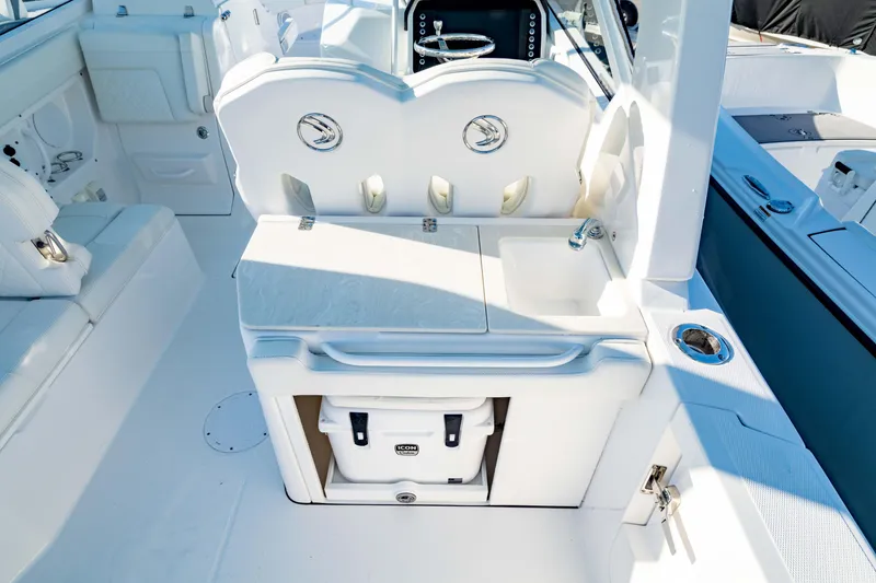 Slide: The Image of 2022 Edgewater 262 CX boat interior with seating, storage, and cooler. - 14