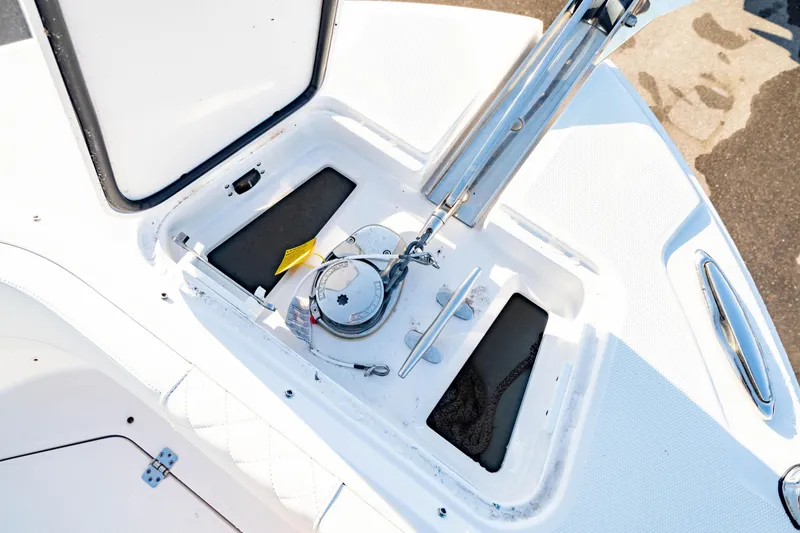 Slide: The Image of 2022 Edgewater 262 CX boat anchor compartment with open hatch and visible anchor mechanism. - 18