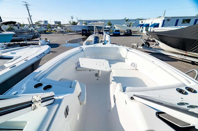Slide: The Image of 2022 Edgewater 262 CX boat interior at a marina, showcasing seating and deck layout. - 22
