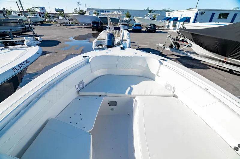 Slide: The Image of 2022 Edgewater 262 CX boat with spacious seating, parked in a marina. - 23