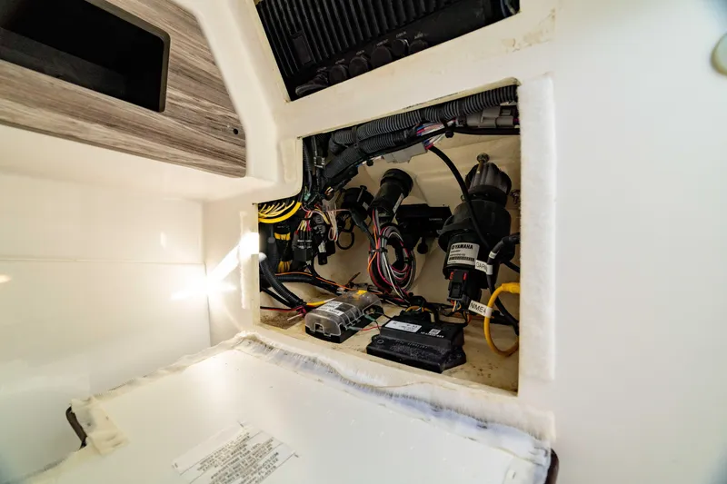 Slide: The Image of 2022 Edgewater 262 CX boat wiring compartment with cables and components. - 24
